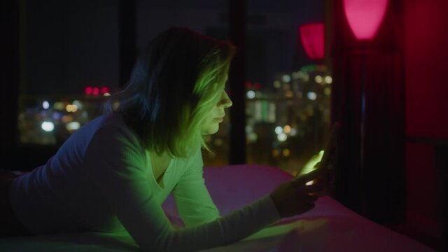 Woman lay down on bed and use of mobile phone at night