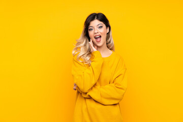 Teenager girl isolated on yellow background surprised and shocked while looking right