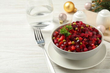 Traditional Russian salad vinaigrette served on white wooden table
