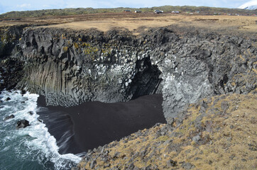 Hexagonal Basalt Columns with a Black Sand Beach and Waves