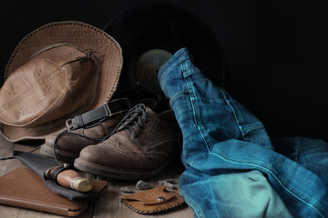 leather cowboy hat, jeans, male shoes, watch, knife, e-book, real man's thing concept, masculinity, modern lifestyle