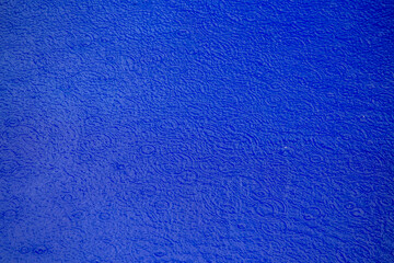 Rain drop on swimming pool, blue background