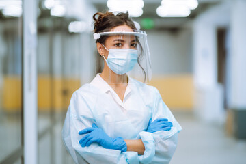 Disease control expert in visor and protective gloves  with an Infrared thermometer equipment to check the temperature at office during pandemic in quarantine. COVID-19.