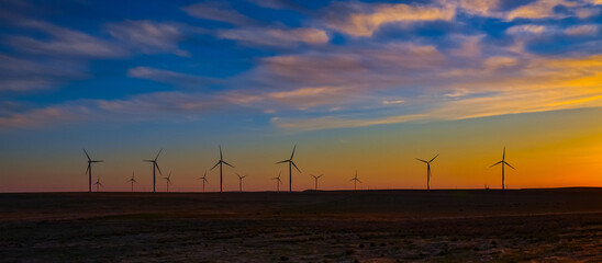 Fototapeta premium Wind turbines at sunset in the state of Idaho, Scenic view of wind turbines power generator