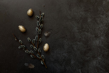 Happy Easter concept. Preparation for holiday. Golden decorated easter eggs willow feather on trendy grunge scratched dark black shale background. Simple minimalism flat lay top view, copy space