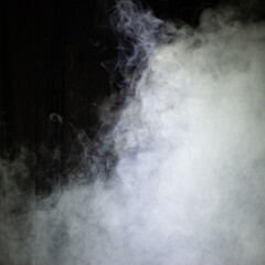 Fototapeta na wymiar Artificial fog and haze on a dark background of the scene.
