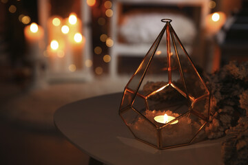 Stylish lantern with burning candle and Christmas decor on table indoors, space for text. Interior...