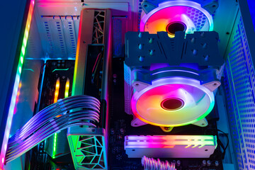 Inside view of custom colorful illuminated bright rainbow RGB LED gaming pc. Computer power hardware and technology concept background