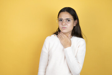 Obraz premium Beautiful child girl wearing casual clothes touching painful neck, sore throat for flu, clod and infection