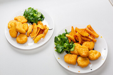 Chicken nuggets with french fries and salad for kids menu.