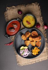 bafle or bati is popular main course dish in India served with dal daal brinjal curry jaggery gud and clarified butter or ghee