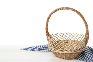 Empty wicker basket and cloth on wooden table against white background, space for text. Easter holiday