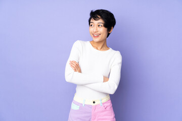 Young Vietnamese woman with short hair over isolated purple background happy and smiling