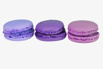 three macaroons in blue, violet and purple, isolated on white background