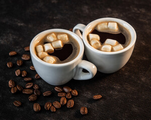 Coffee in white cups and small marshmallows. Turkish coffee, marshmallows on a dark background. Close-up. Two cups of coffee with marshmallows, coffee beans