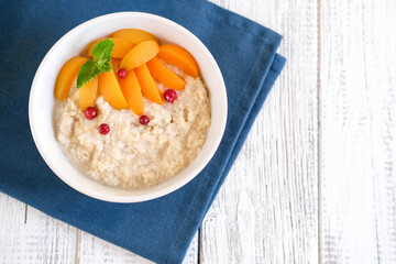 Healthy breakfast. Apricots crumbling with berries and mint in ceramic plates. Top view