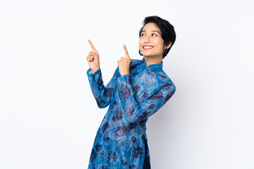 Young Vietnamese woman with short hair wearing a traditional dress over isolated white background pointing with the index finger a great idea