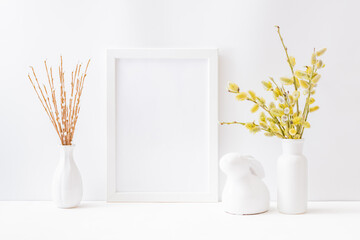 Home interior with easter decor. Mockup with a white frame and willow branches in a vase on a light background