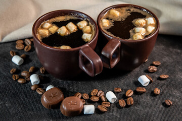 Coffee in brown cups and marshmallows. Coffee break concept. Turkish coffee, marshmallows on a dark background. Close-up. Two cups of coffee with marshmallows, coffee beans