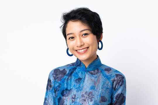 Young Vietnamese woman with short hair wearing a traditional dress over isolated white background