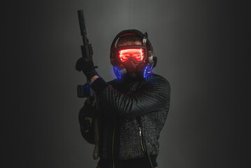 Futuristic soldier with a rifle in the gas mask on the dark background.