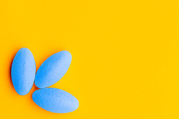 blue pills on orange yellow background