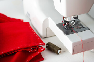 Modern sewing machine with red fabric, cutting and sewing at home, home leisure and hobby