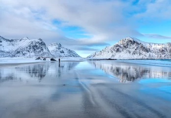 Wall murals Reflection Snowy mountains and blue sky with clouds reflected in water in winter. Arctic sandy beach in Lofoten islands, Norway. Landscape with snow covered rocks, nordic sea coast, sand. Nature background 