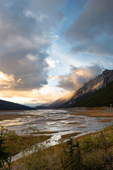 Canada, Alberta. Alluvial valley at sunset with golden light and clouds, Jasper National Park.
