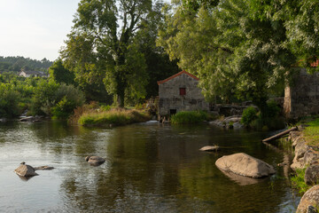 River beach in Vila Verde with a waterfall and water mill in Portugal