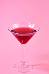 glass of red martini on pink background