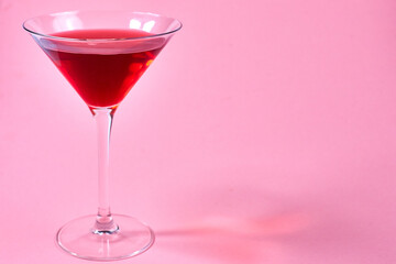 glass of red martini on pink background