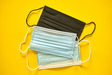 Prevent coronavirus. Protective medical antibacterial blue face mask on a yellow background. Concept of prevention from respiratory sickness and viruses. Covid-19 concept