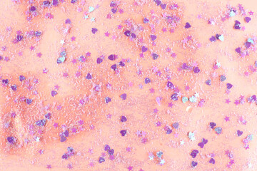 Shiny glitter on light pink background, top view