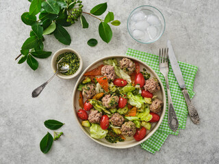 Meatballs with cherry tomatoes and salad.