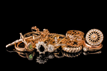 A golden scrap of old gold jewelry on black background
