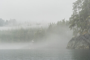 Canada, British Columbia. Fog envelopes the shore of Hansen Island on Blackfish Sound.