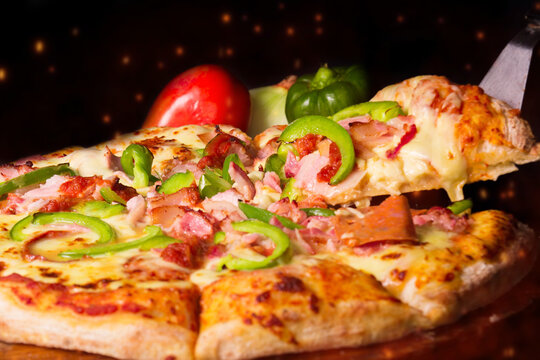 Pizza de pepperoni con piment&oacute;n, fondo con tomate, cebolla, piment&oacute;n, fondo negro.