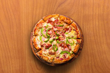 Fototapeta na wymiar Pizza de pepperoni con pimentón, mesa de madera-