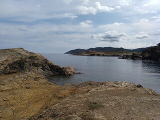 Mar en calma en S'Arenella, en Port de la Selva, con el faro al fondo