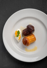 Italian dessert baba from Naples in white plate on black table, top view