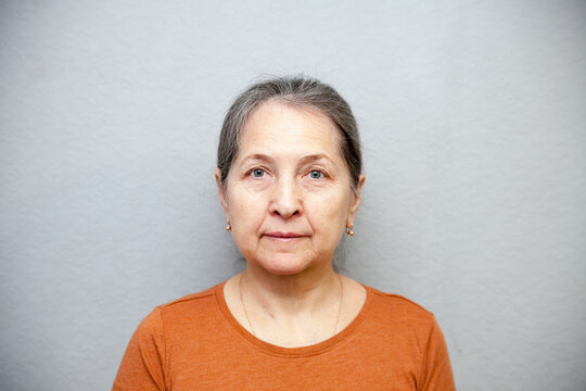 Senior Woman In  Studio  On Grey Wall Serious