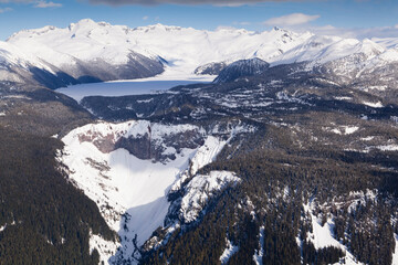 Aerial view of frozen Garibaldi Lake and lava barrier in the foreground.