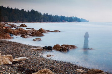 Long exposure of a ghostly image of woman on the beach in Sechelt, British Columbia, Canada