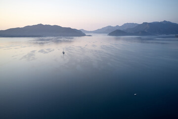 Beautiful seascape background. Sea, mountains and beautiful sunset sky. Picturesque marine scene.