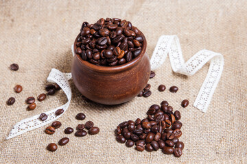 Coffee beans scattered in a heart on a clay pot table