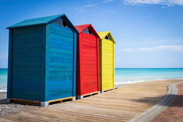 Naklejka premium Colorful huts on the way to wood on the beach