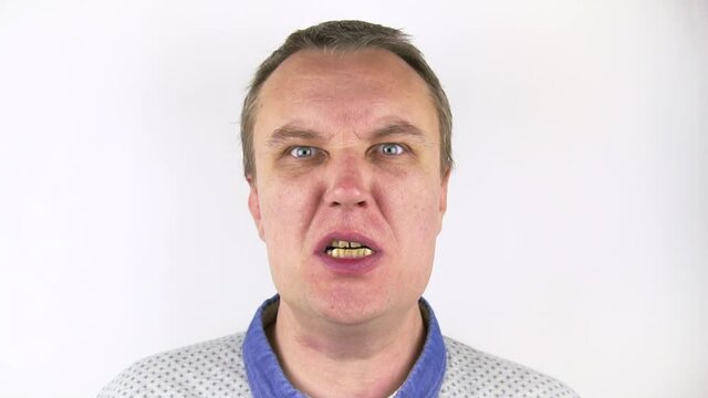 A portrait of an angry man who gets a slap in the face and grimaces in pain. The woman's hand hits the man in the face. White background. Close-up.