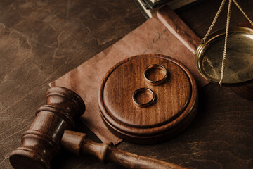 Divorce and separation concept. Wooden gavel and golden rings in notary public office.