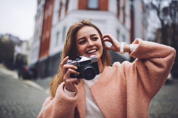 Smiling female photographer taking picture of old street